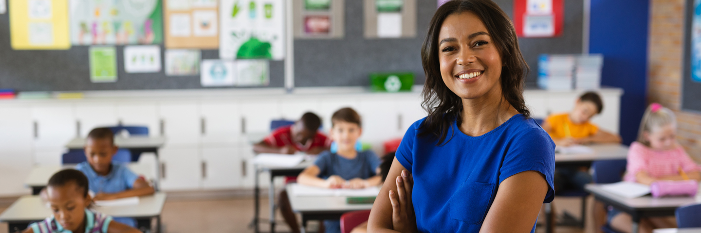 Teacher standing next to children in a classroom