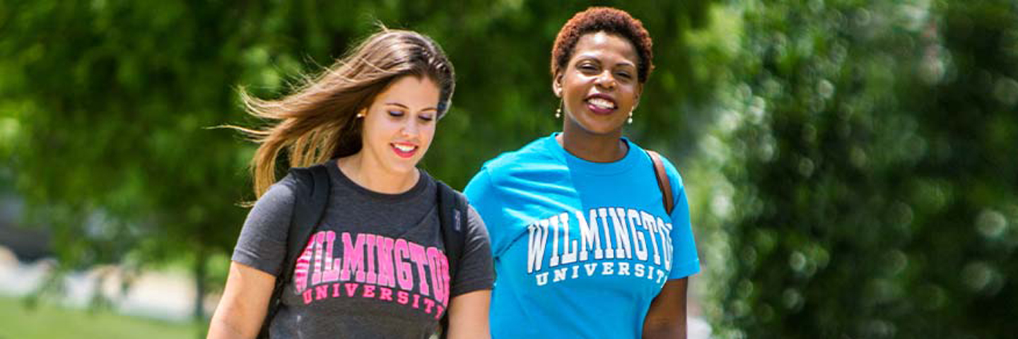two classmates walking in Wilmington University shirts