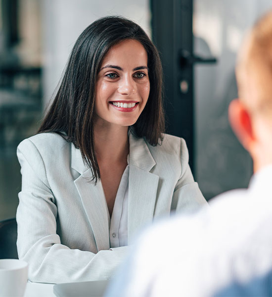 Woman sitting talking to another person.